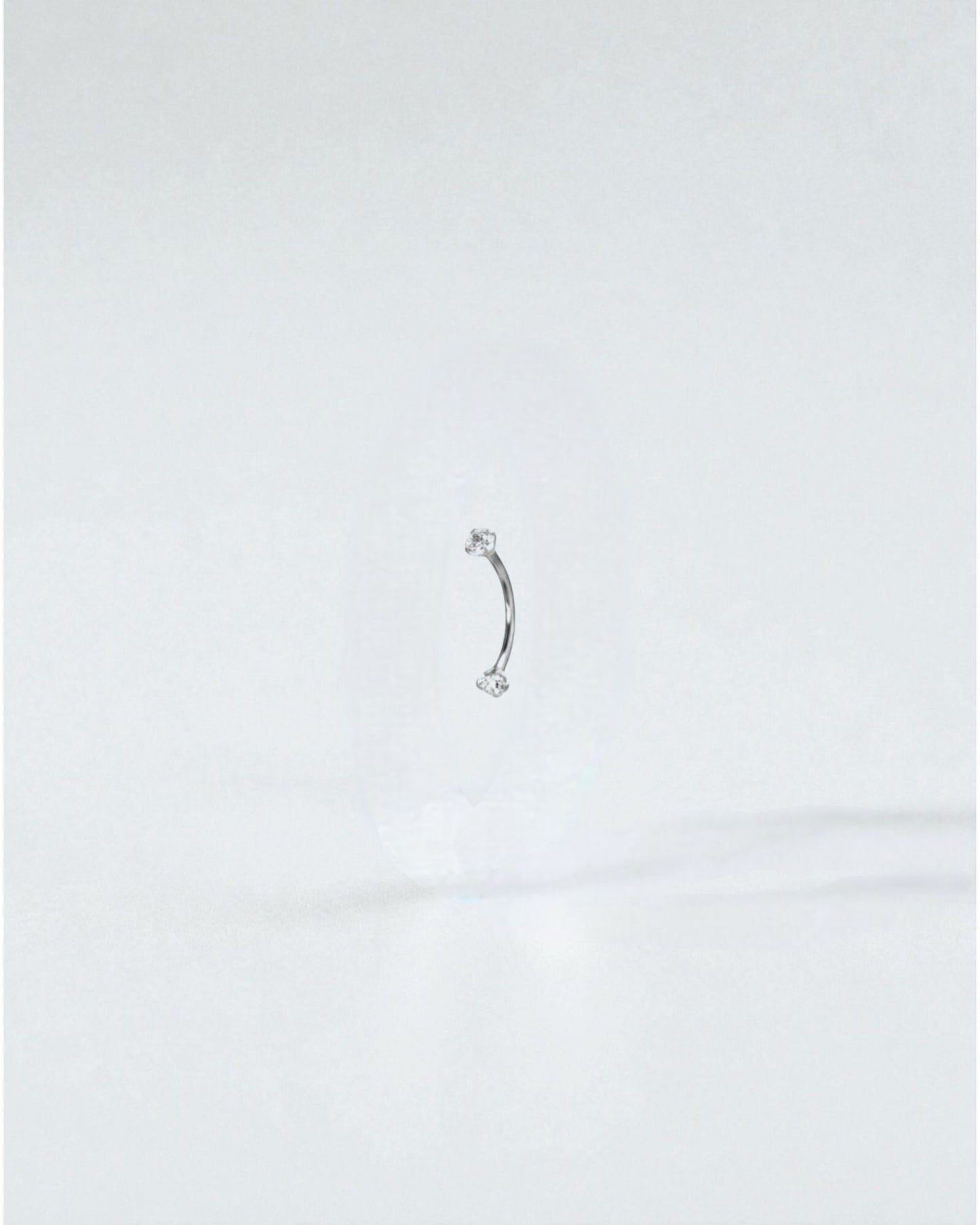Odonata gold titanium curved barbell with white cubic zirconia ends, 6mm length, 16g gauge.