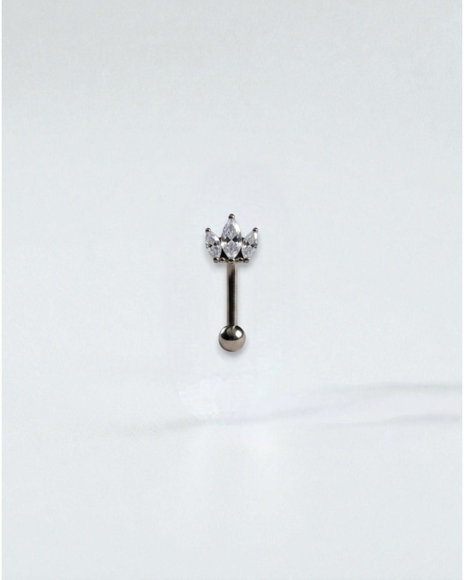 Odonata Banana Corona Marquise belly button ring with three marquise-cut white cubic zirconia stones and a titanium post.