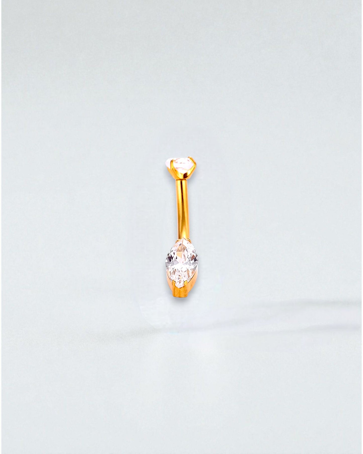 Odonata gold-tone titanium belly button piercing with a round cubic zirconia top and a marquise-cut cubic zirconia drop.