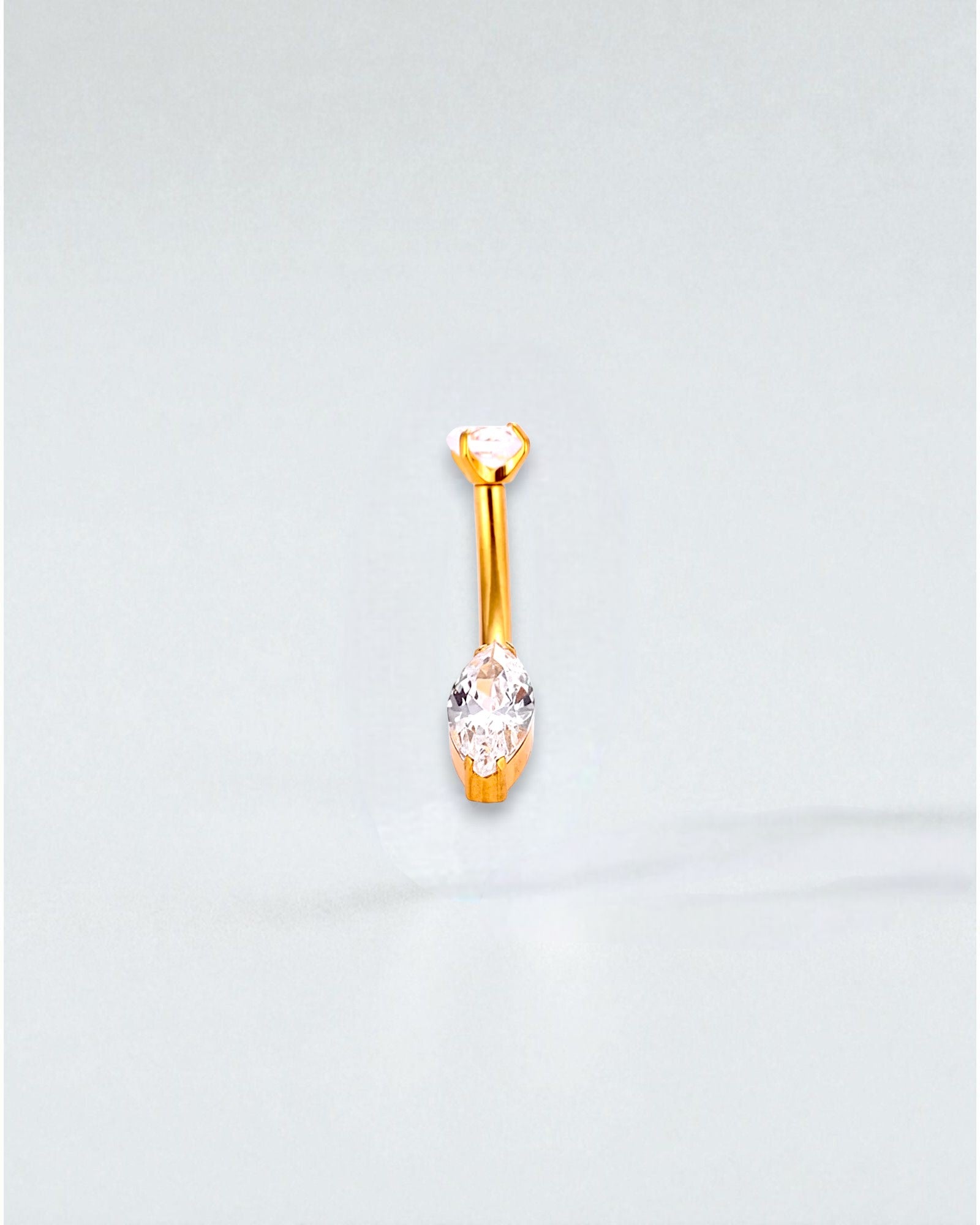 Odonata gold-tone titanium belly button piercing with a round cubic zirconia top and a marquise-cut cubic zirconia drop.
