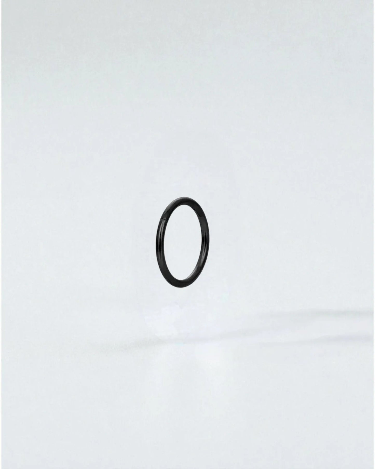 Odonata black stainless steel clicker hoop earring with gold plating, 8mm inner diameter.