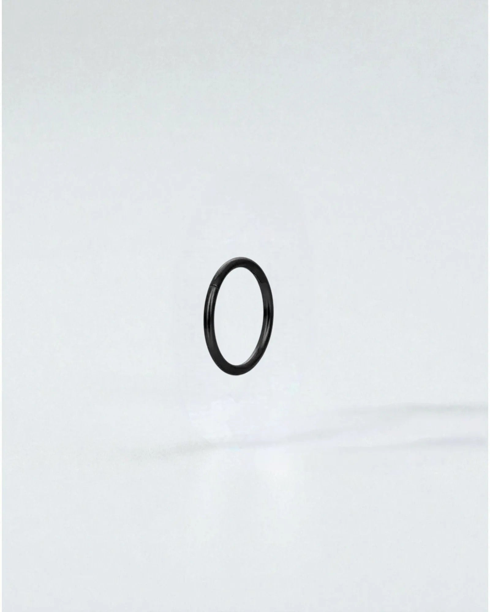 Odonata black stainless steel clicker hoop earring with gold plating, 8mm inner diameter.