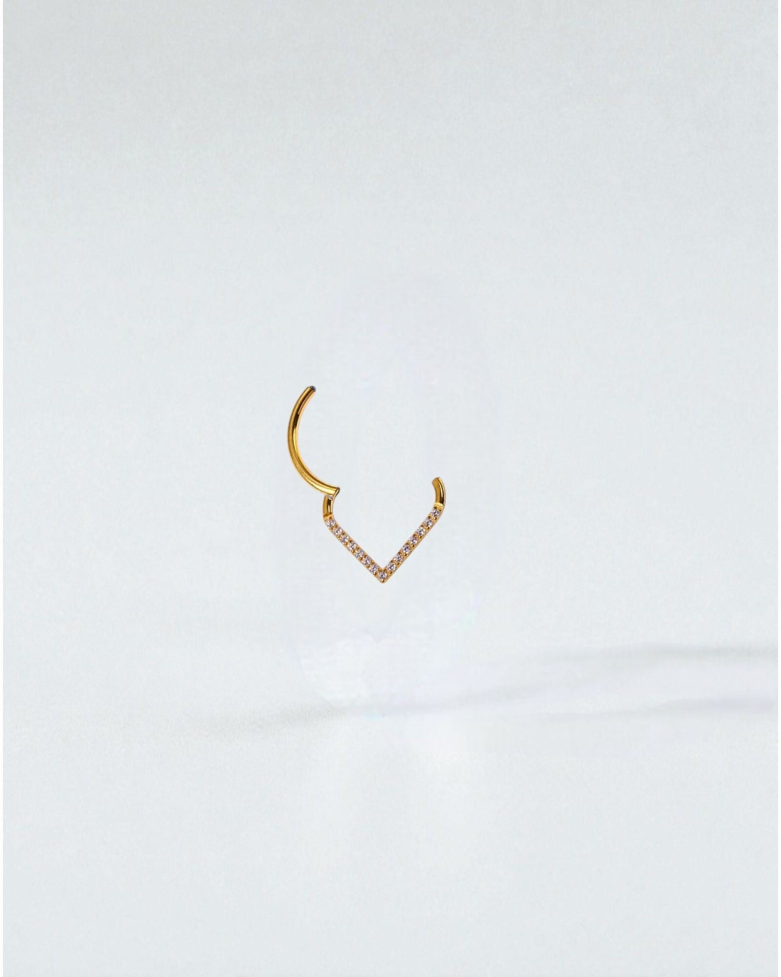 Odonata gold and silver clicker earrings with V-shaped design and white cubic zirconia stones, 8mm diameter.