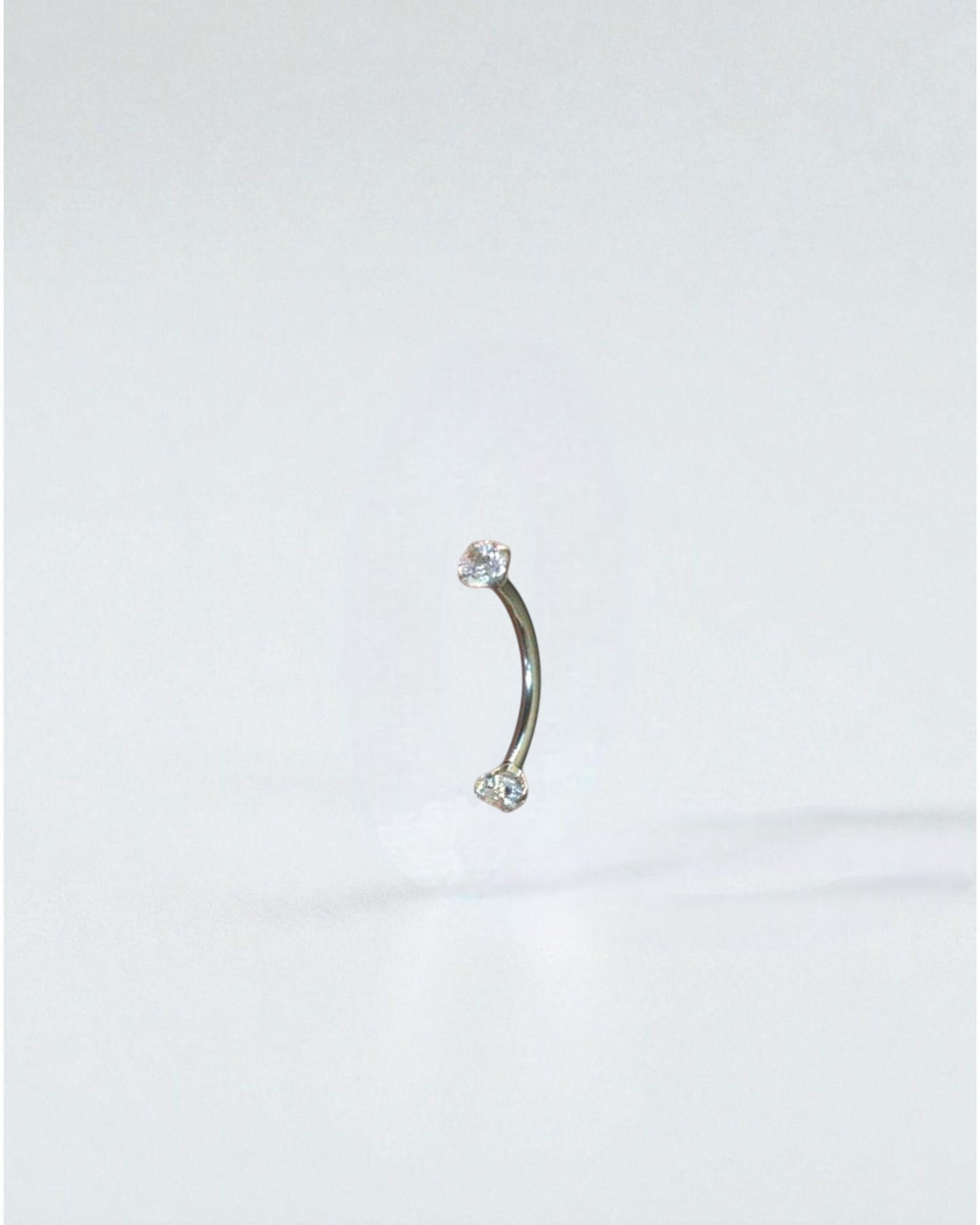 Odonata curved barbell 10mm titanium with two clear cubic zirconia ends, ideal for eyebrow piercings.
