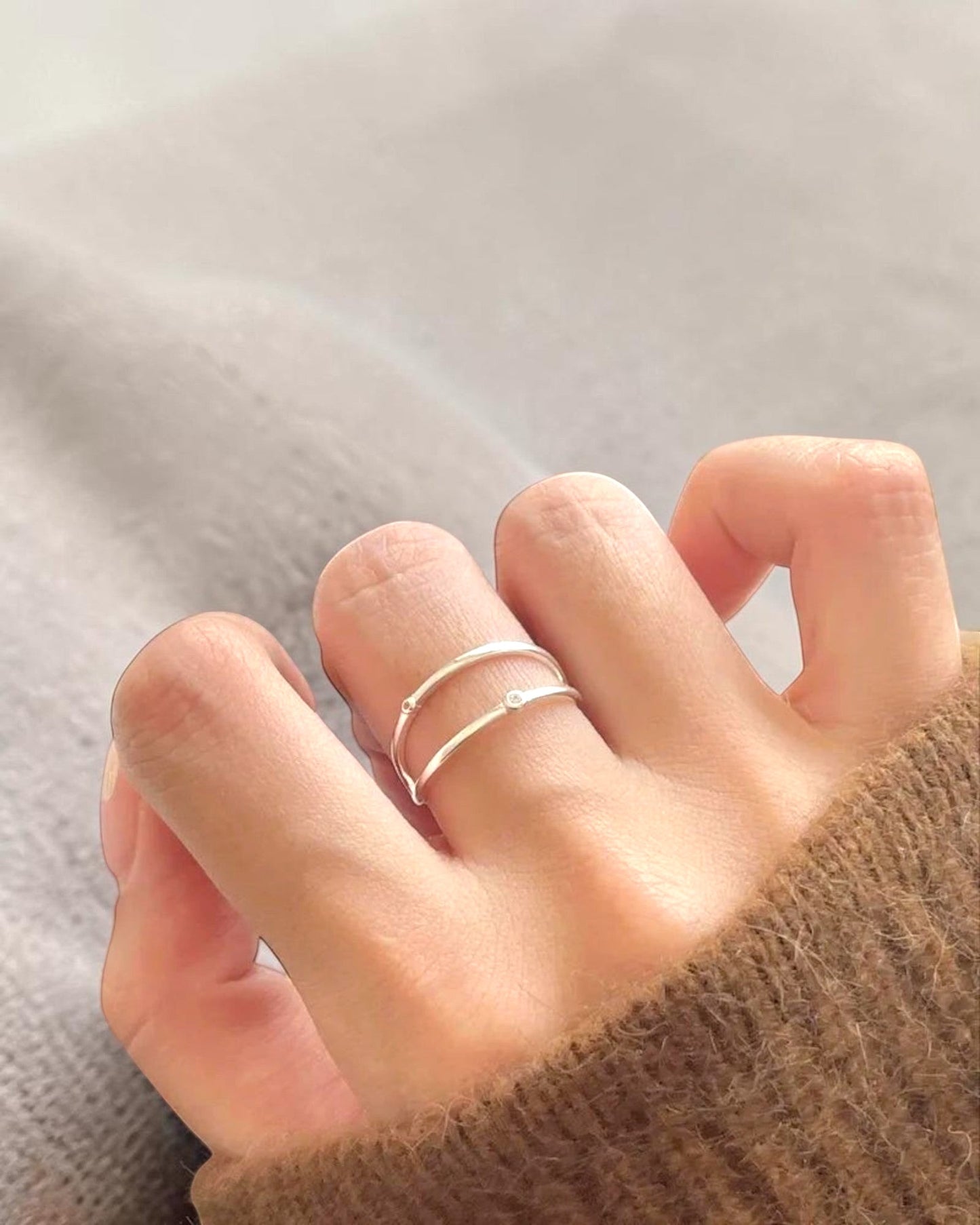 Odonata minimalist double band ring in sterling silver with 18k gold plating and small cubic zirconia stones.