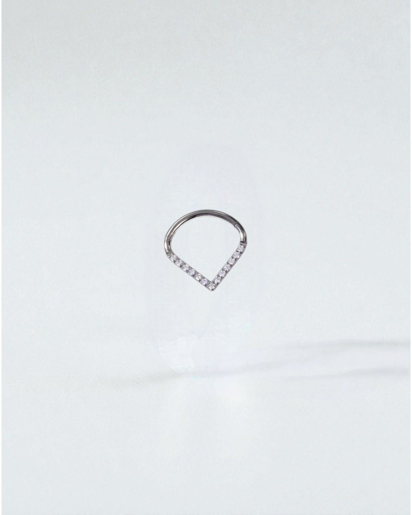 Odonata titanium clicker earring with white cubic zirconia in a drop shape, 10mm inner diameter.