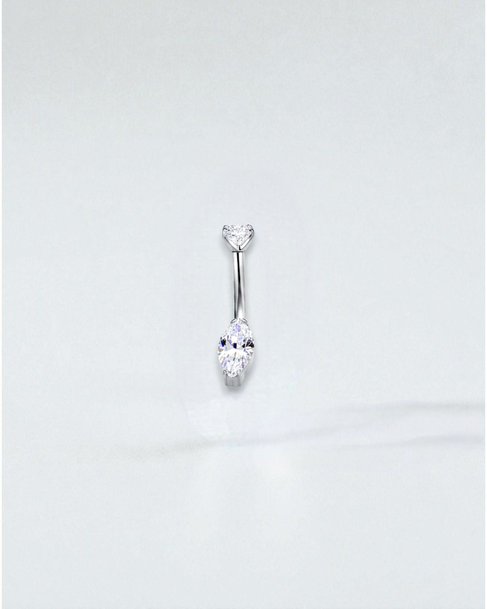 Odonata gold titanium belly button piercing with a round cubic zirconia top and a marquise-cut cubic zirconia drop.