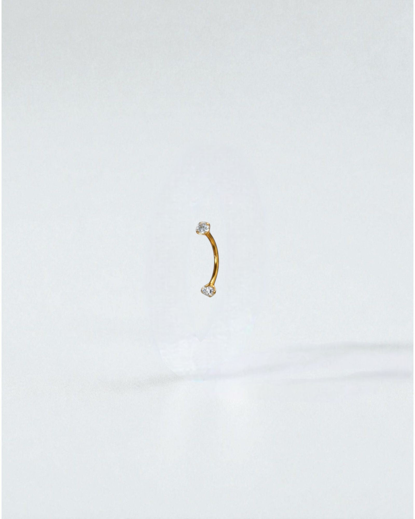 Odonata gold titanium curved barbell with white cubic zirconia ends, 6mm length, 16g.