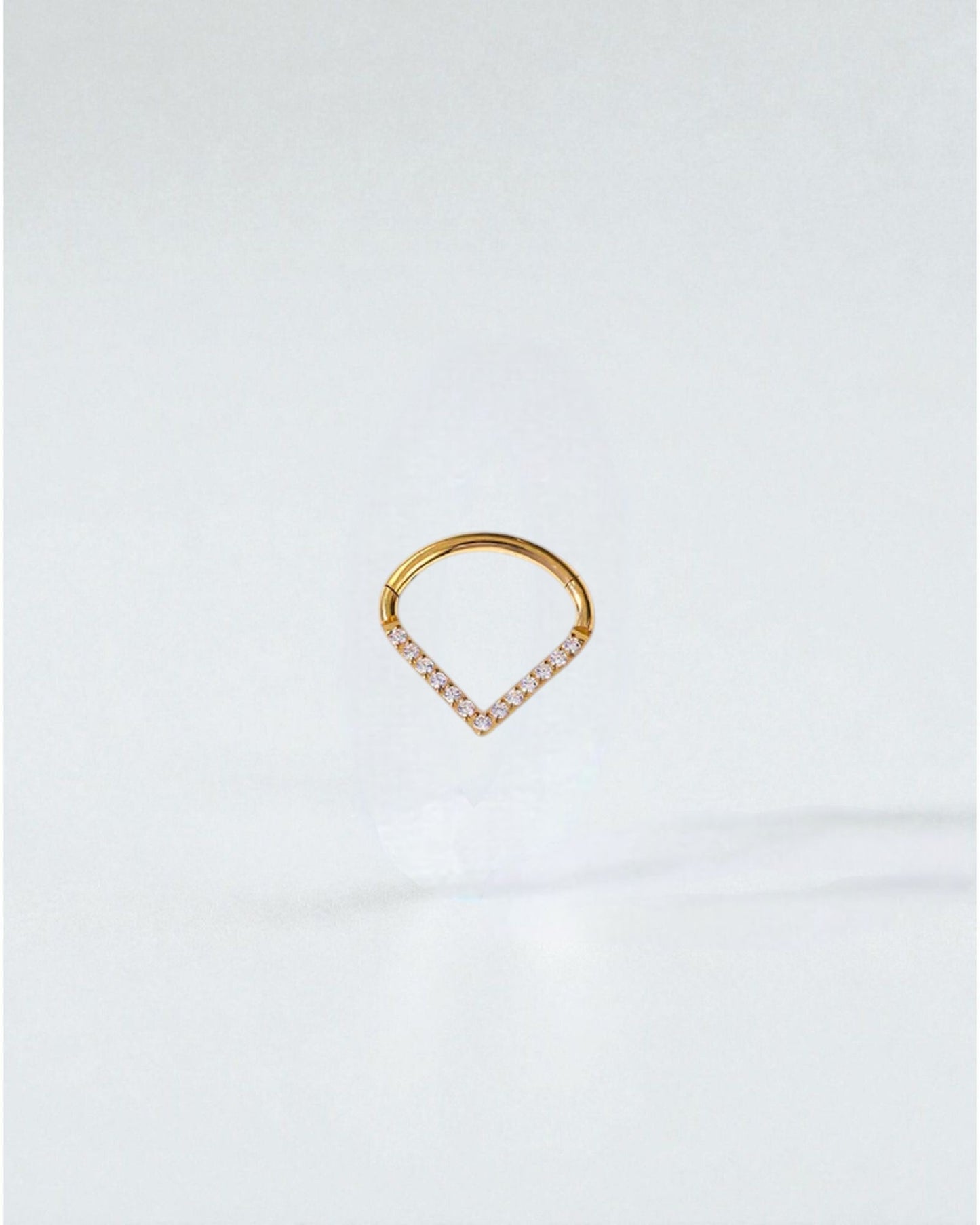 Odonata gold clicker piercing with a V-shaped design adorned with white cubic zirconia stones. Available in three sizes.