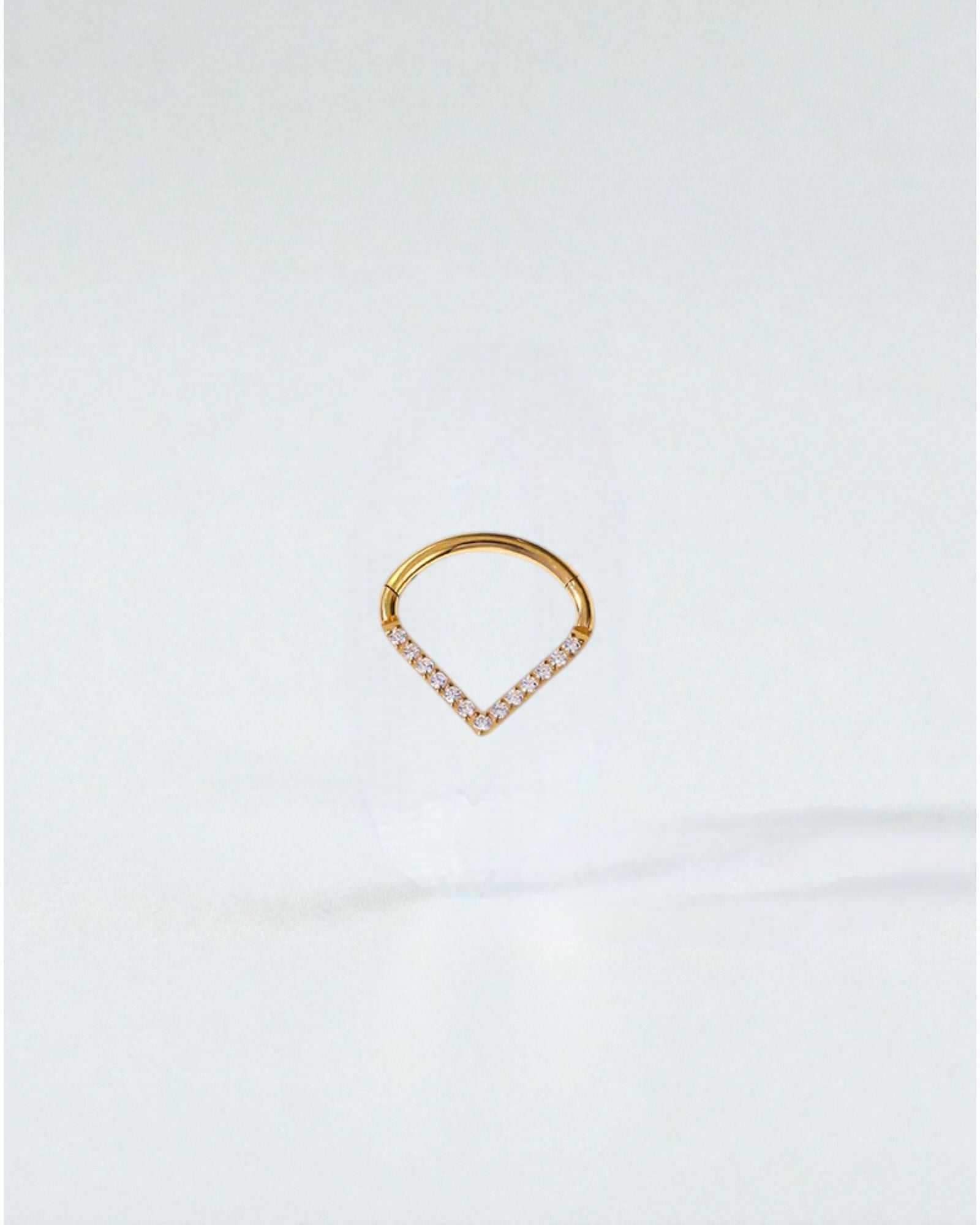 Odonata gold clicker piercing with a V-shaped design adorned with white cubic zirconia stones. Available in three sizes.