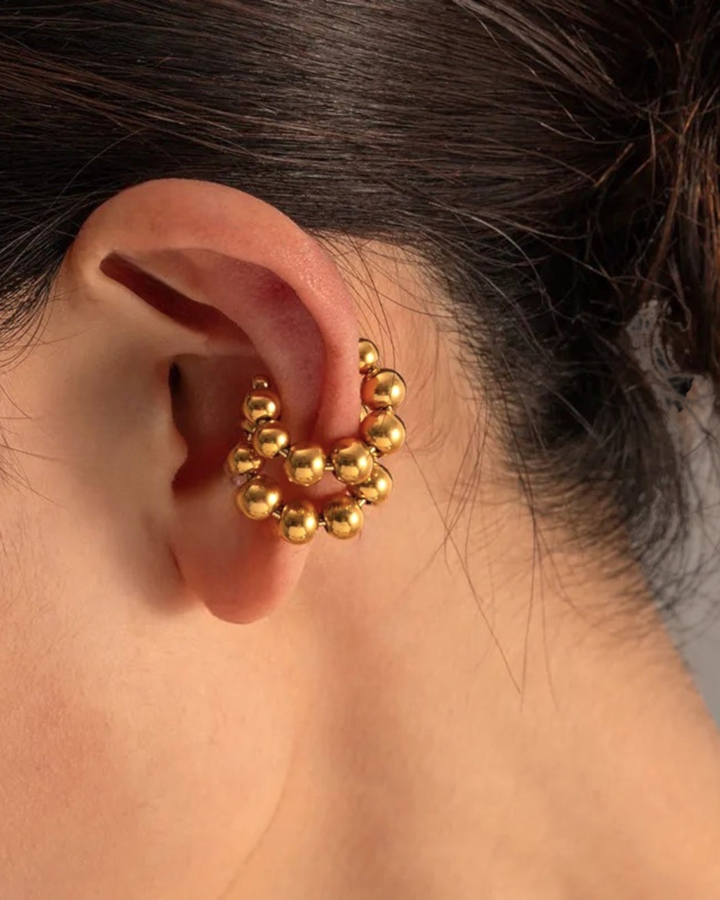 Odonata gold stainless steel cuff earrings with a double row of small spheres, contemporary design.