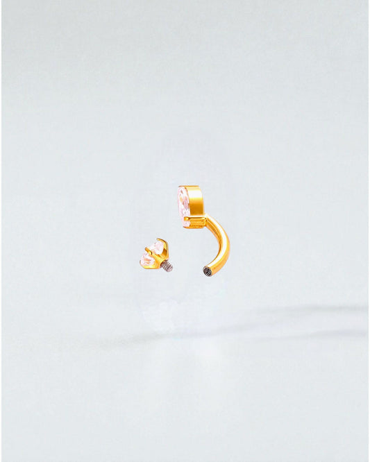 Odonata gold titanium belly button piercing with cubic zirconia drop and round stones. Internal screw closure.