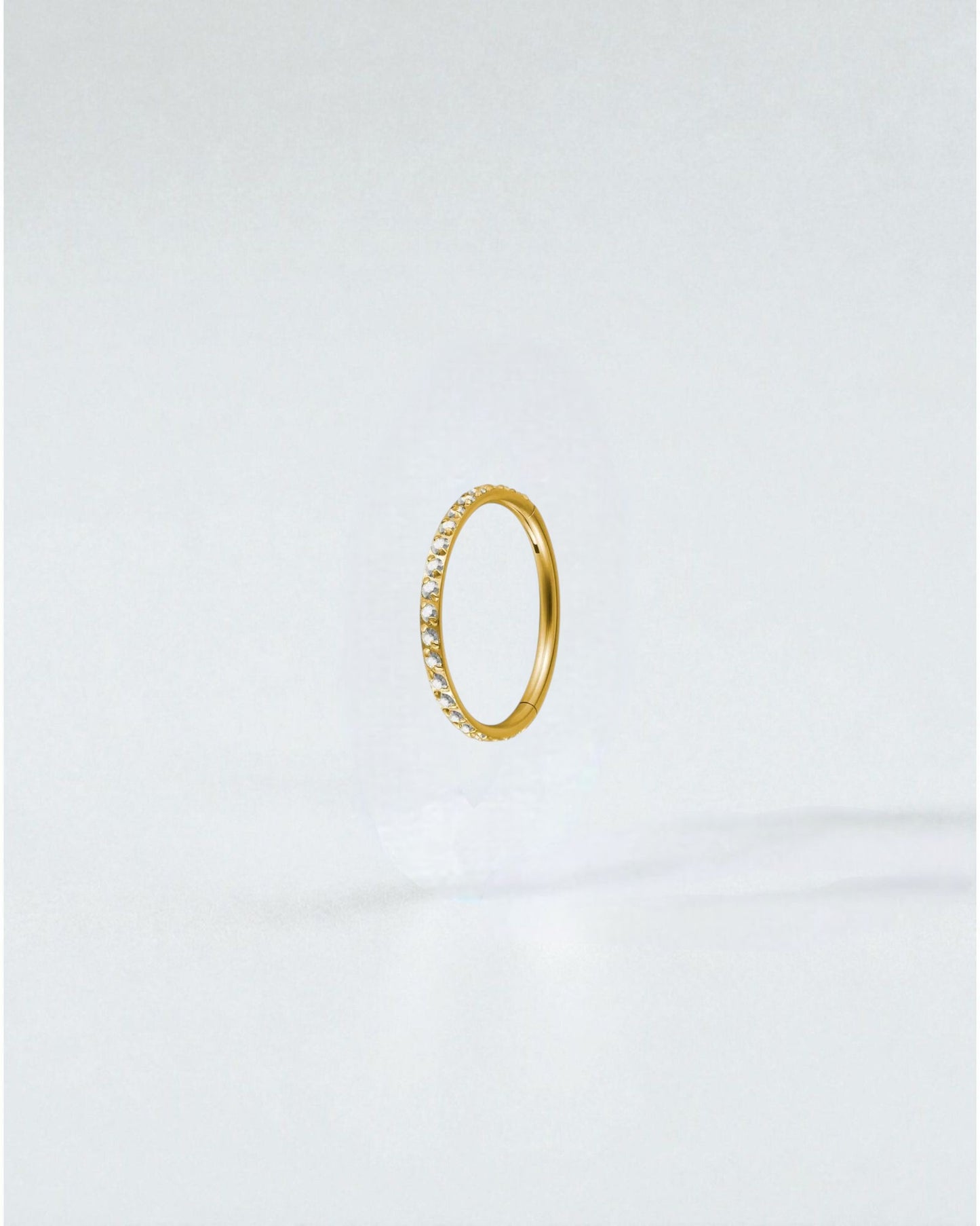 Odonata gold titanium clicker hoop earring with clear cubic zirconia stones, 8mm diameter.