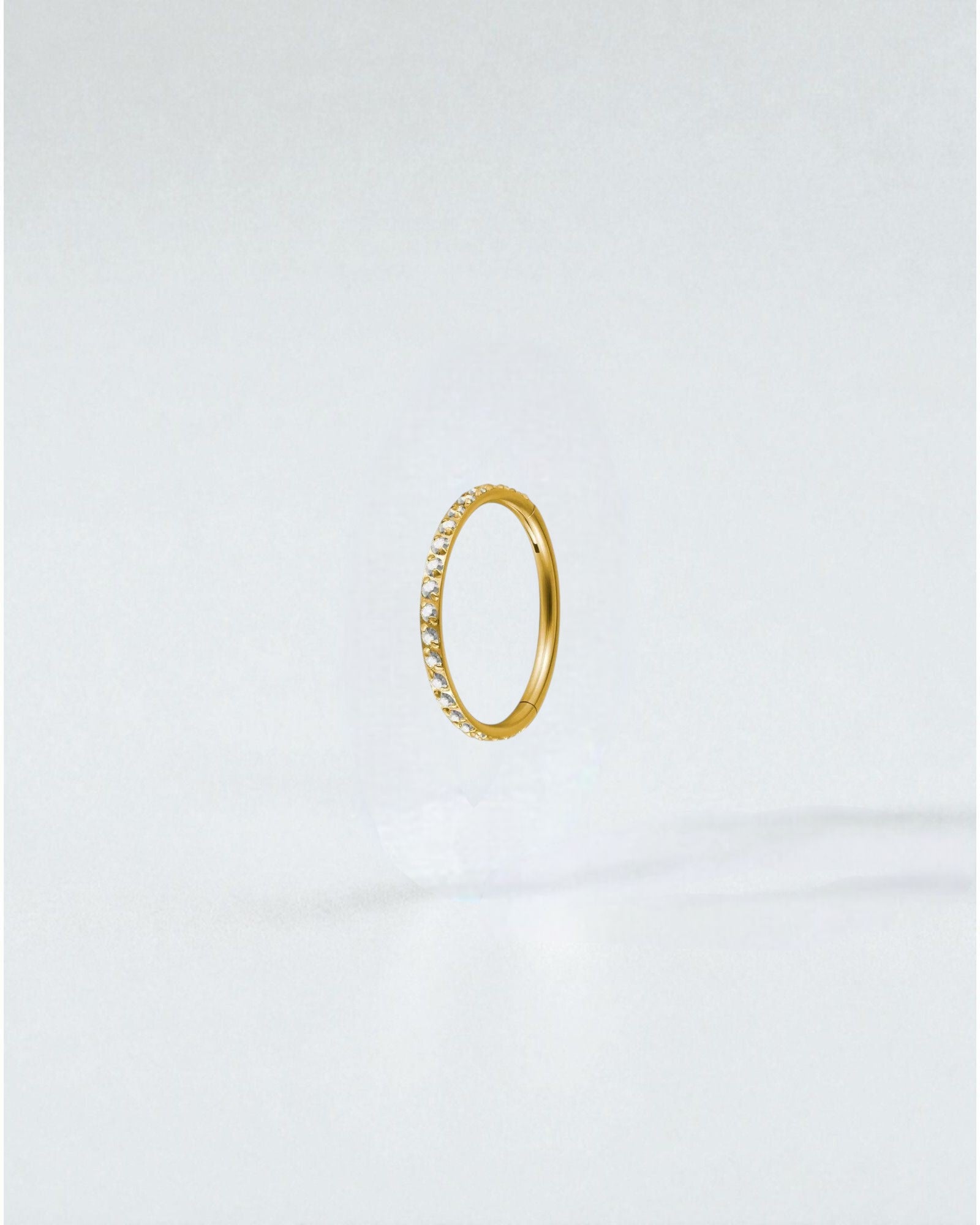 Odonata gold titanium clicker hoop earring with clear cubic zirconia stones, 8mm diameter.