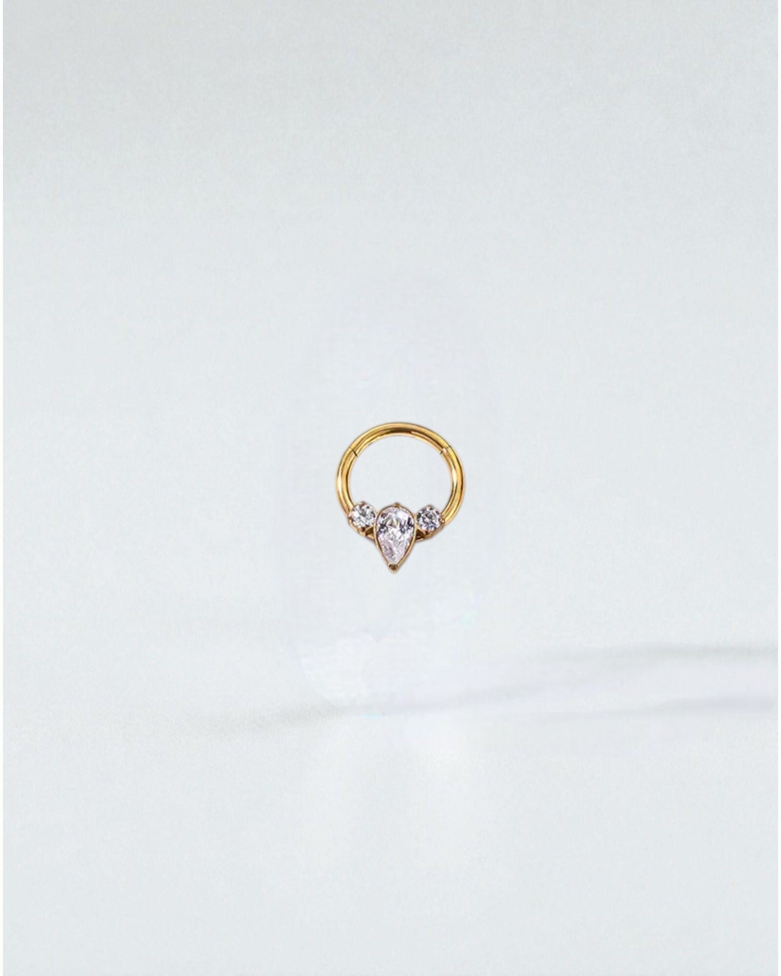 Odonata gold implant grade titanium clicker hoop earrings with clear cubic zirconia gems. Styles 1-7 shown.