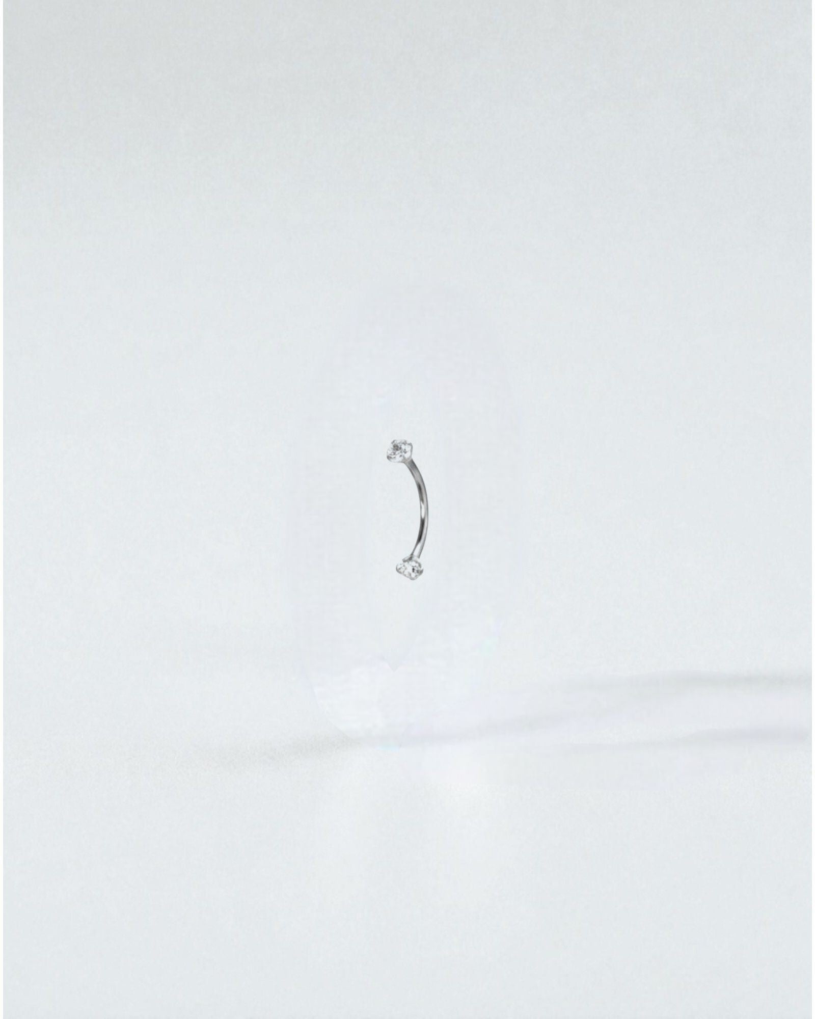Odonata gold titanium curved barbell with white cubic zirconia ends, 6mm length, 16g gauge.