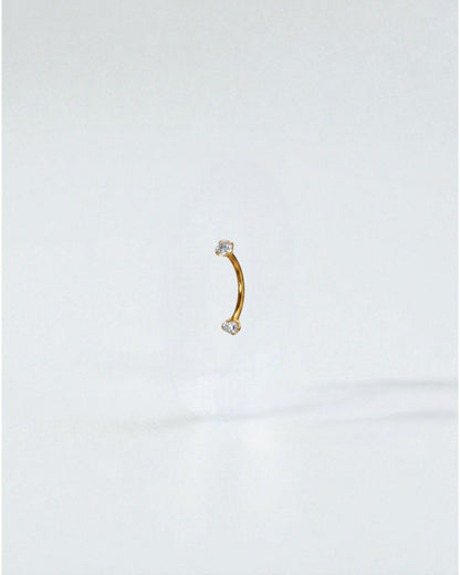 Odonata gold titanium curved barbell with clear cubic zirconia ends, 8mm length, 16G thickness.