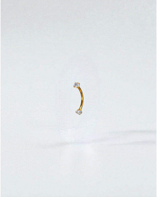 Odonata gold titanium curved barbell with clear cubic zirconia ends, 8mm length, 16G thickness.