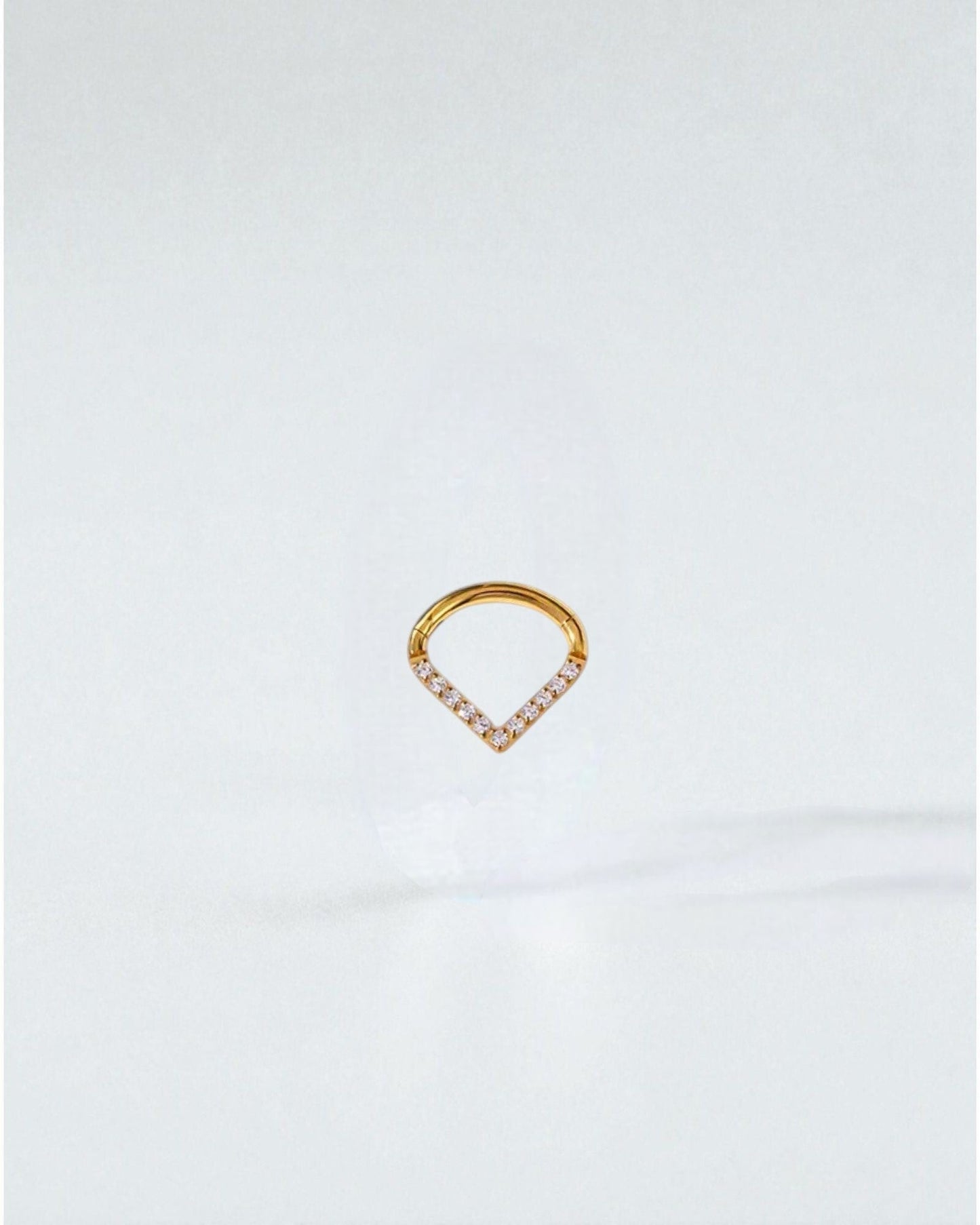 Odonata gold-tone titanium clicker earring with V-shaped white cubic zirconia stones, 8mm inner diameter.
