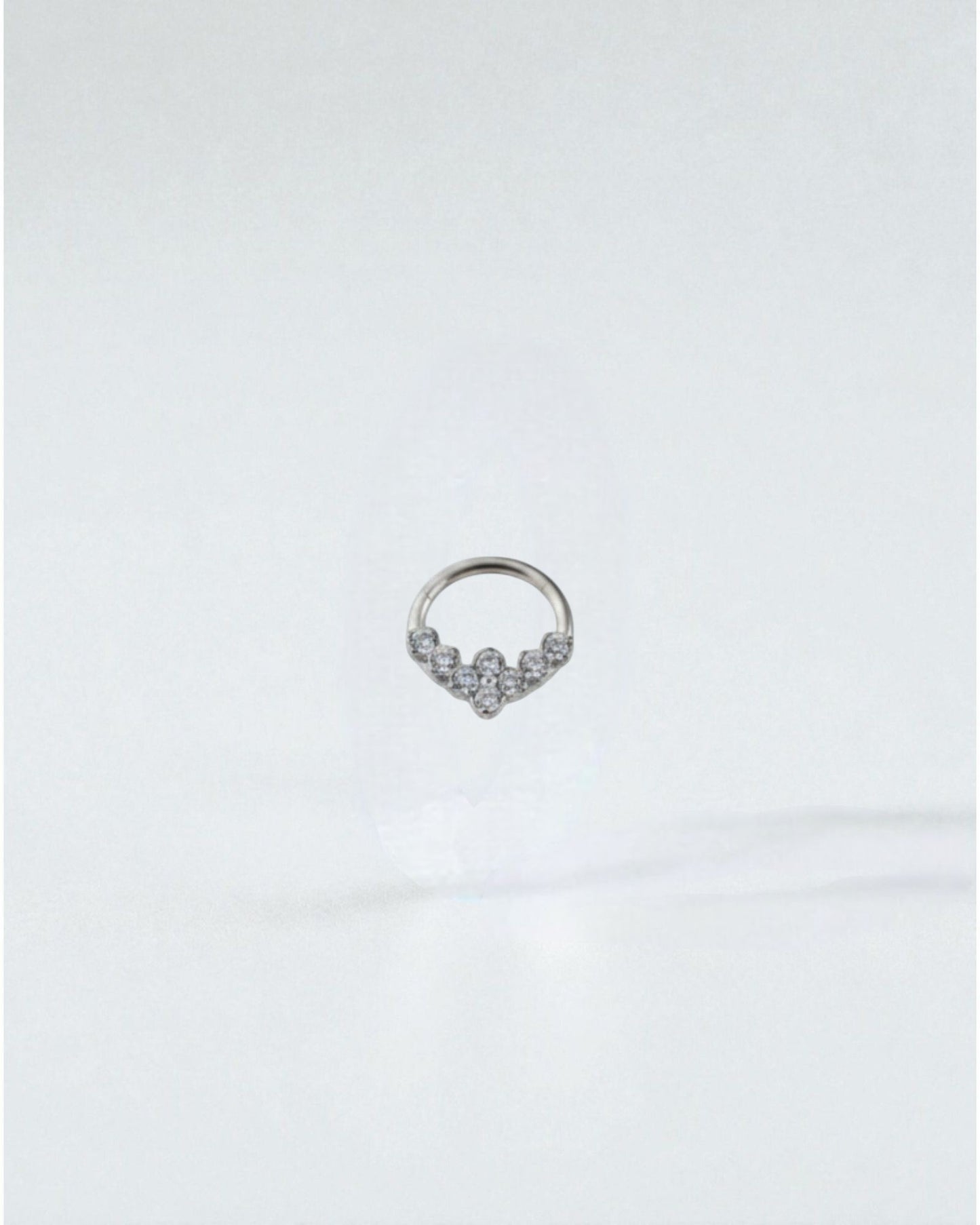 Odonata gold clicker septum or daith piercing with clear zirconias in a V-shape design. Made of titanium.