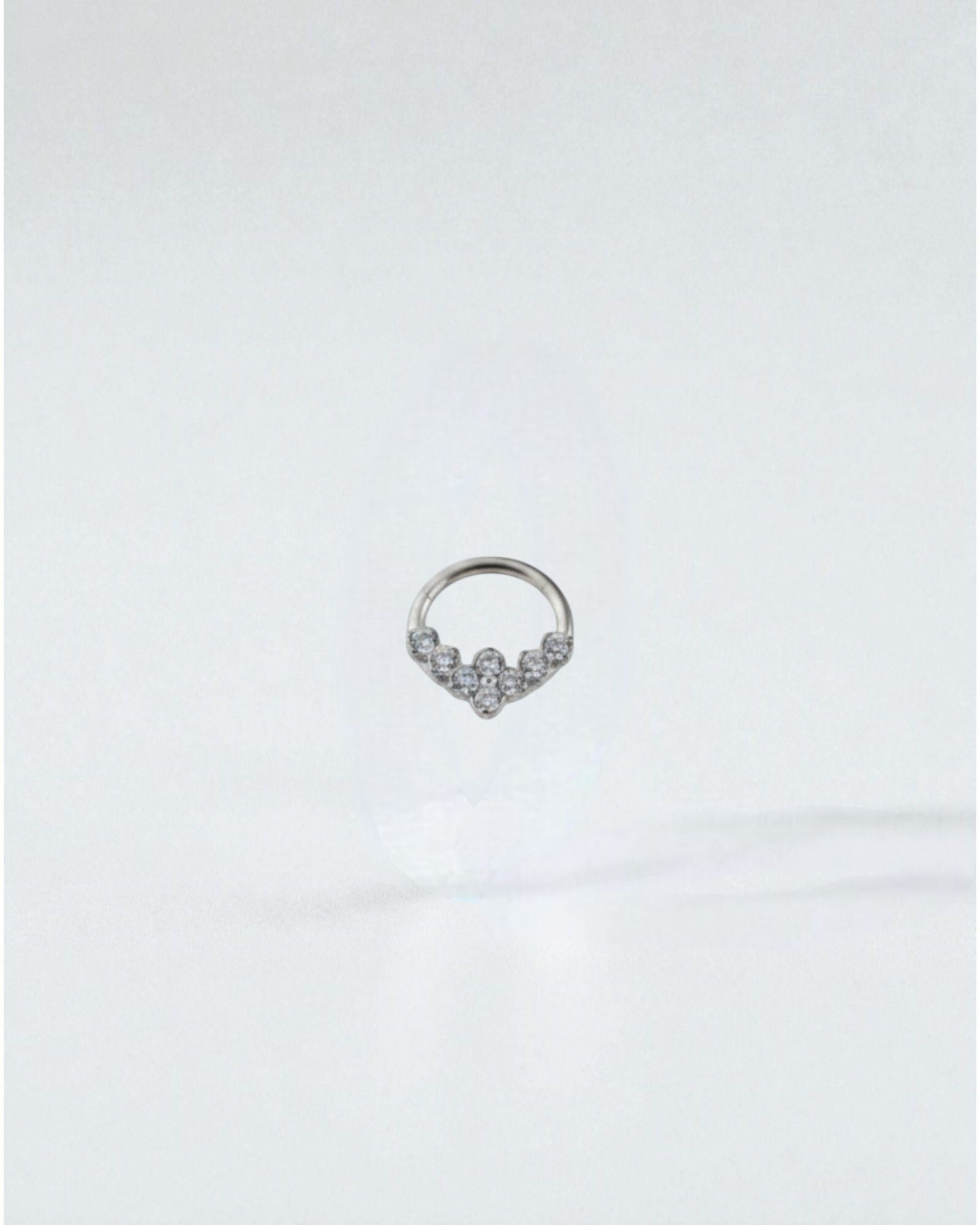 Odonata gold clicker septum or daith piercing with clear zirconias in a V-shape design. Made of titanium.