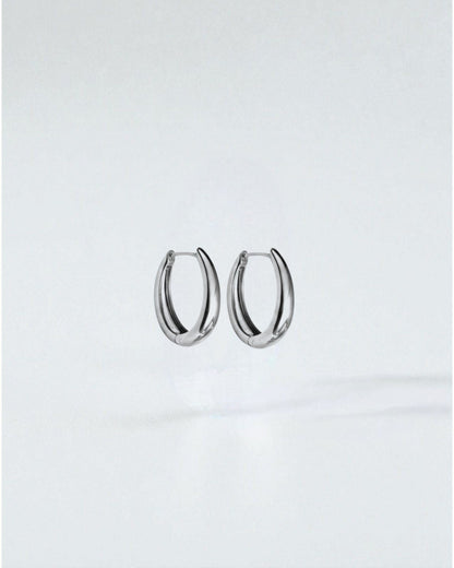 Odonata oval huggie earrings in polished stainless steel with 14k gold plating. Modern, water-resistant design.