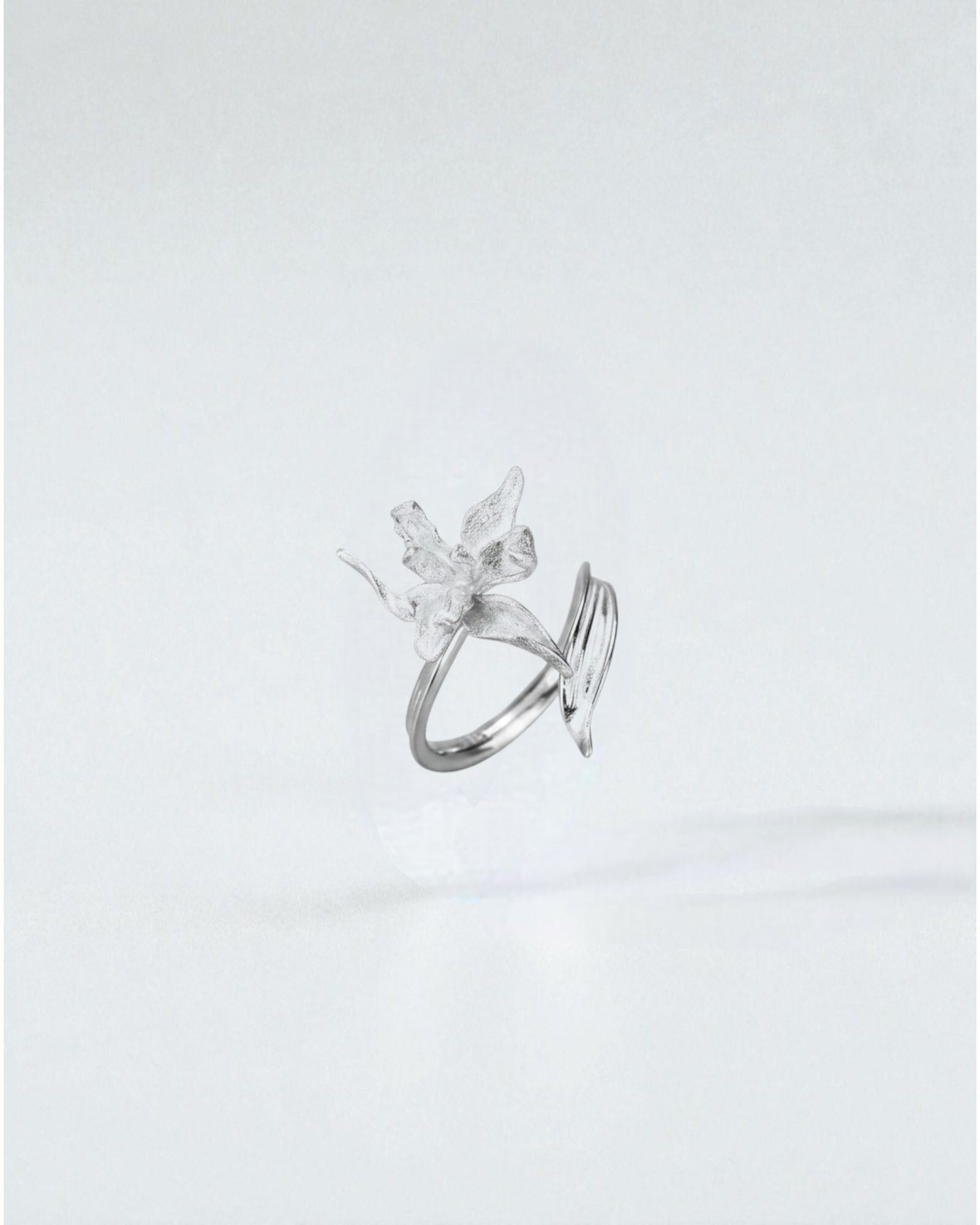 Odonata sculpted flower ring in matte sterling silver with double band, adjustable size.