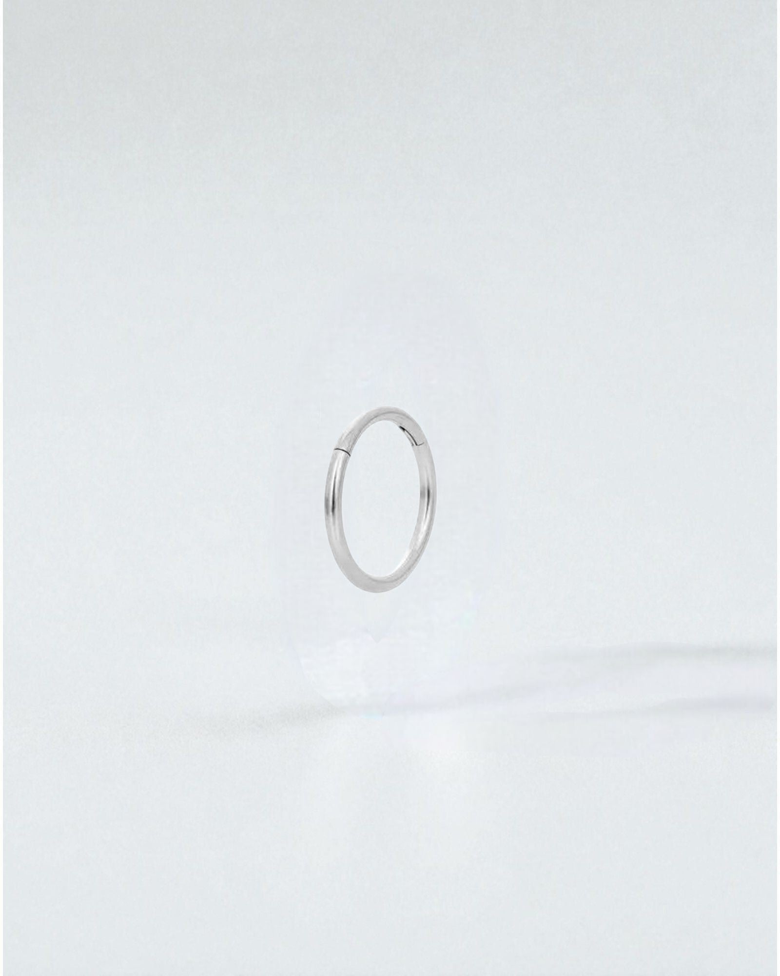 Odonata silver stainless steel clicker hoop earring with 10mm diameter, ideal for a minimalist look.