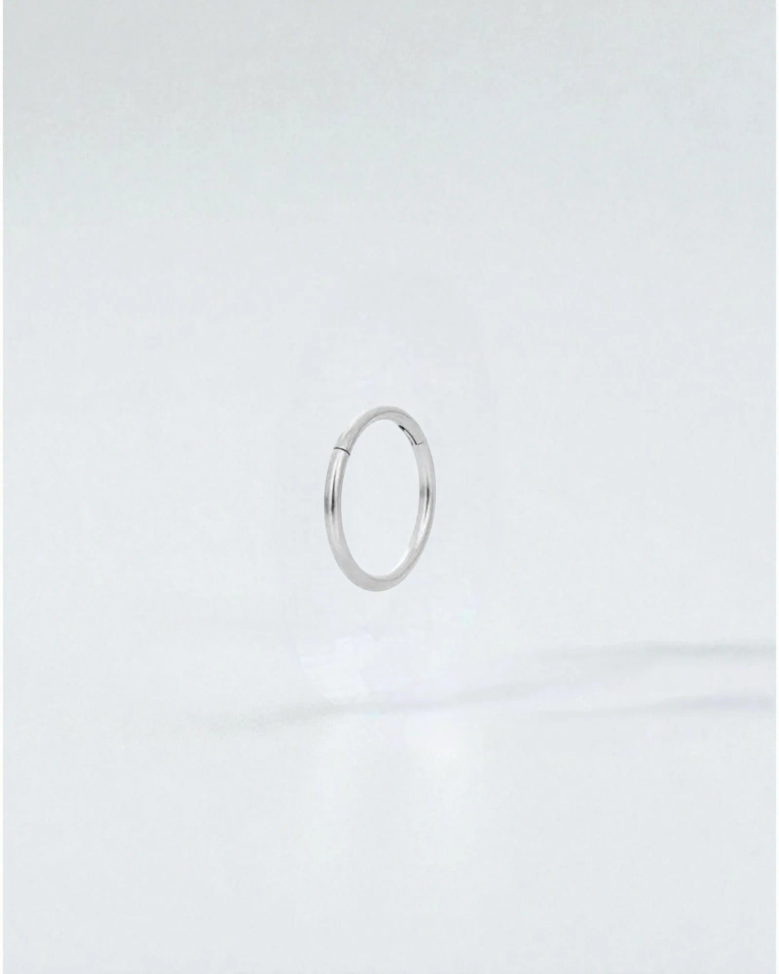 Odonata silver-tone stainless steel 8mm clicker hoop earring with a clean, minimalist design.