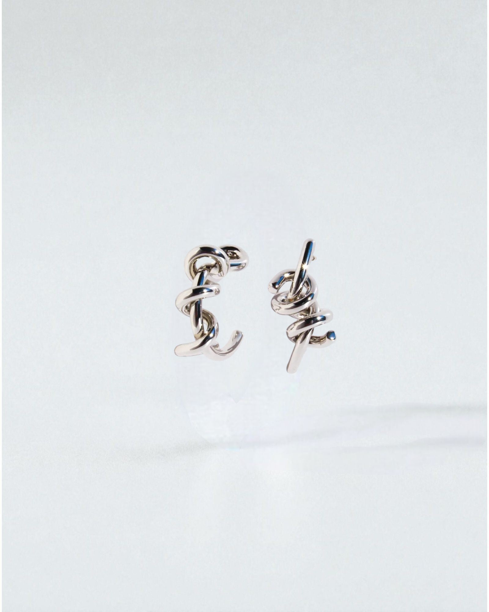 Odonata silver-tone brass twist hoop earrings with 24k gold plating. Modern sculptural design.