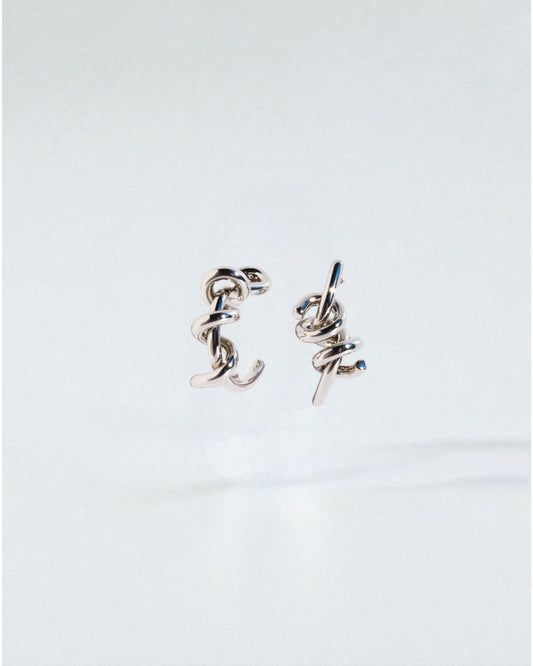 Odonata silver-tone brass twist hoop earrings with 24k gold plating. Modern sculptural design.