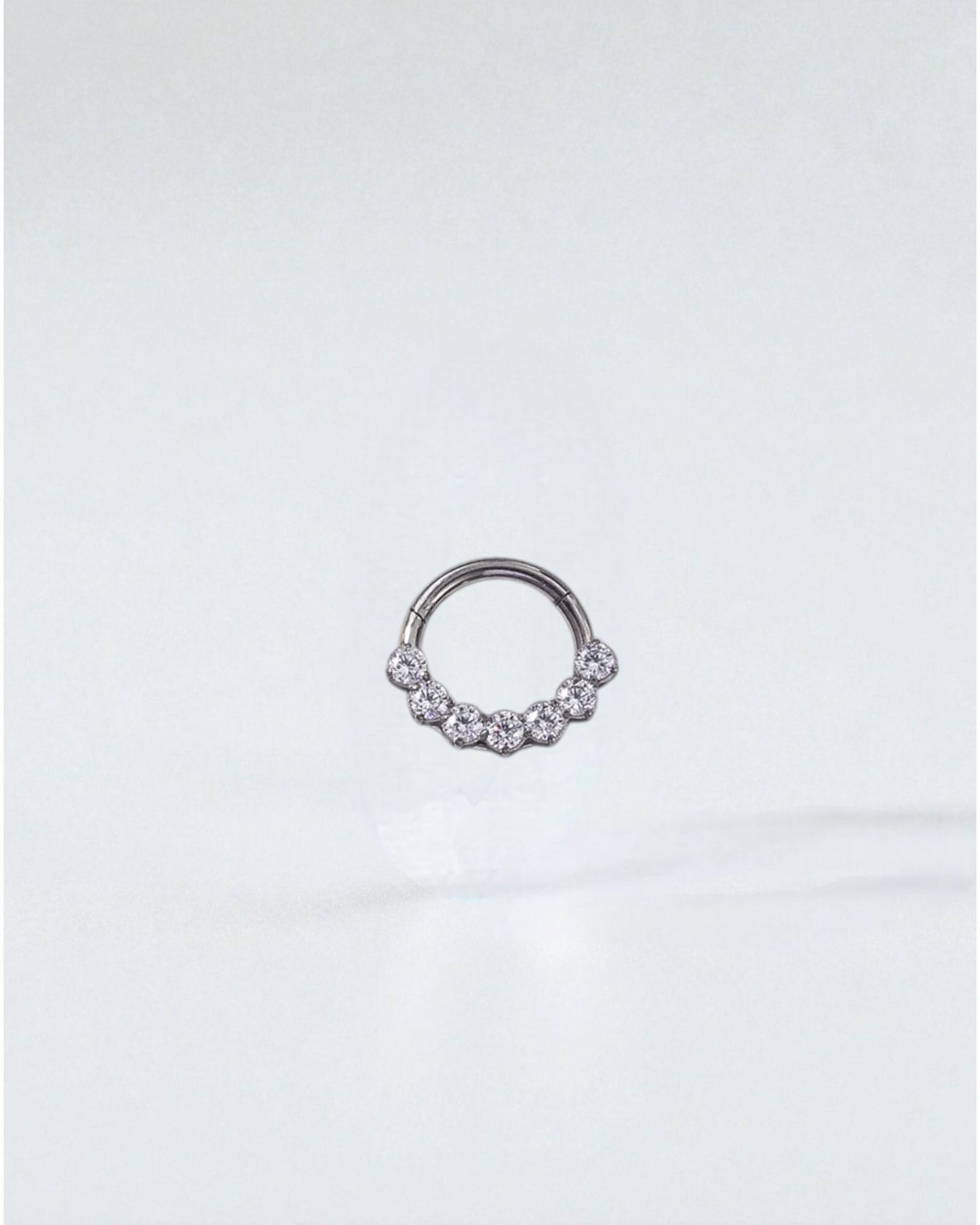 Odonata gold and silver clicker hoop earrings with 7 clear zirconias, 8mm size, 16G thickness, made of implant-grade titanium.