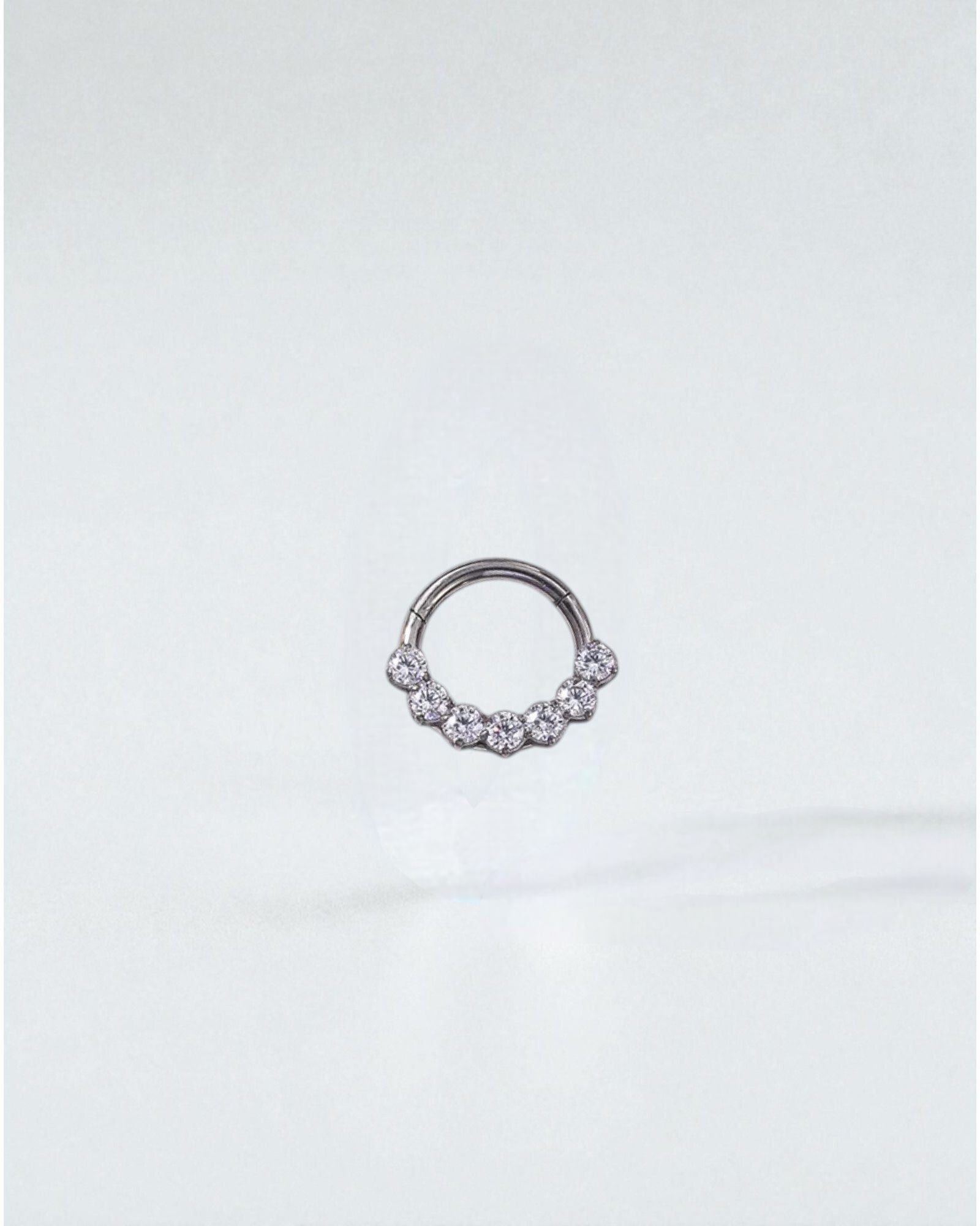 Odonata gold and silver clicker hoop earrings with 7 clear zirconias, 8mm size, 16G thickness, made of implant-grade titanium.